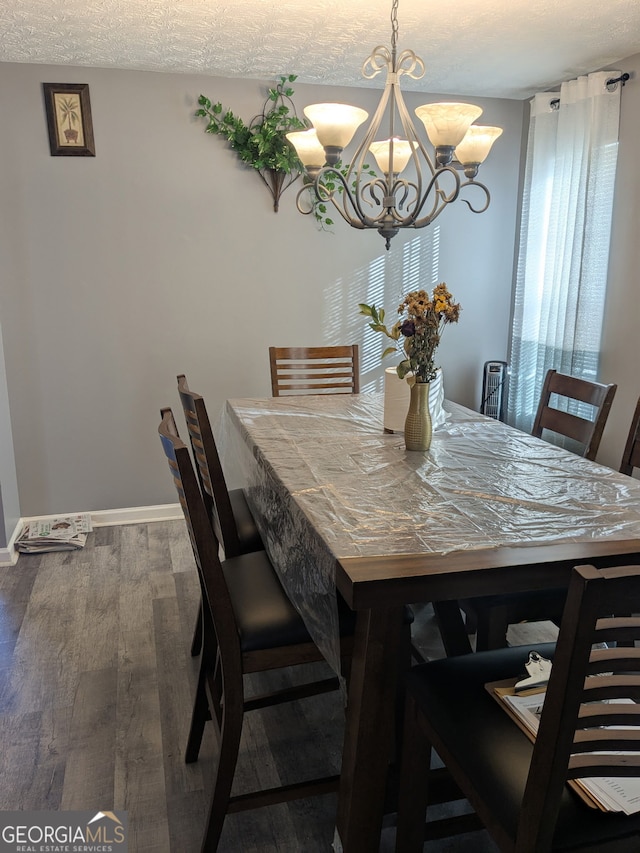 dining room with hardwood / wood-style floors, a textured ceiling, and a chandelier