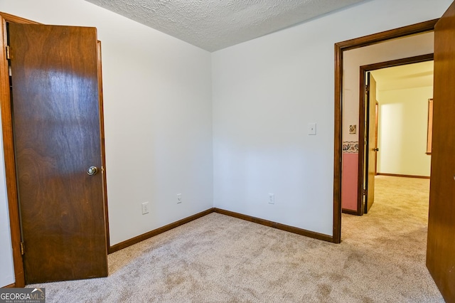 carpeted spare room with a textured ceiling