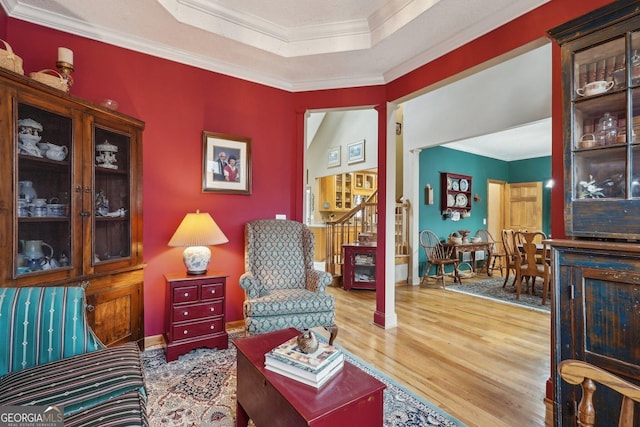 sitting room featuring ornamental molding and wood finished floors