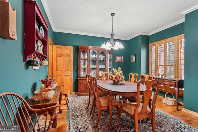 dining room featuring ornamental molding, wood finished floors, a textured ceiling, and an inviting chandelier