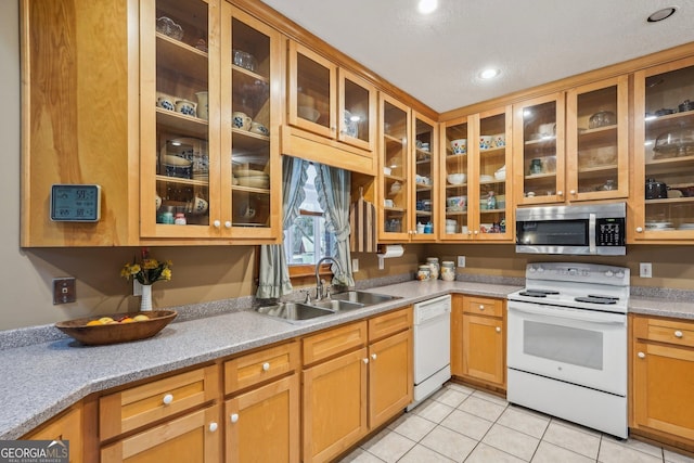 kitchen with sink, white appliances, and light tile patterned floors