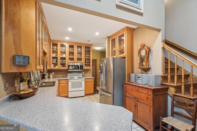 kitchen featuring light stone counters, sink, white appliances, and light tile patterned flooring