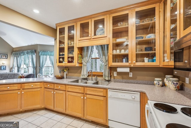 kitchen featuring white appliances, a sink, open floor plan, light countertops, and glass insert cabinets