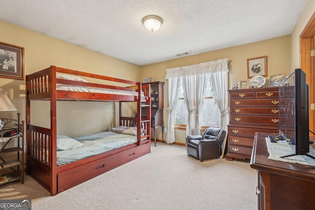 carpeted bedroom featuring a textured ceiling