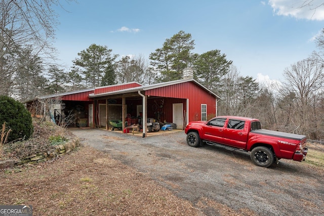 view of pole building with driveway and a carport