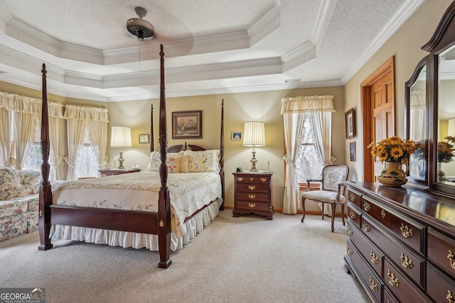 bedroom with a raised ceiling, ornamental molding, light colored carpet, and a textured ceiling