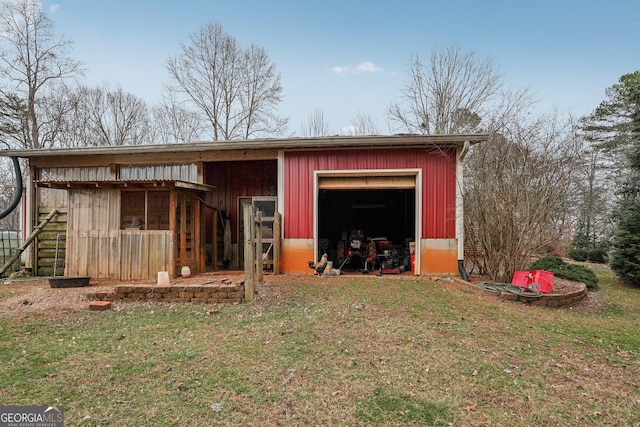 view of pole building with driveway and a lawn