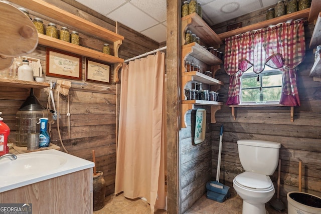 full bathroom with a paneled ceiling, curtained shower, vanity, and toilet