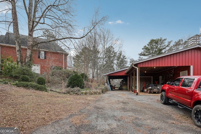 view of home's exterior with a pole building, a detached garage, and an outdoor structure