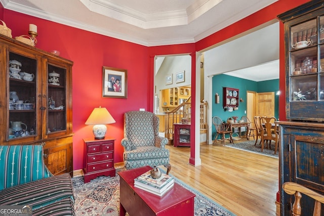 living area with hardwood / wood-style flooring, crown molding, and ornate columns