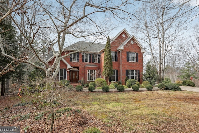 view of front facade with brick siding and a front yard