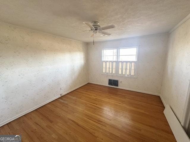 empty room featuring hardwood / wood-style floors, a textured ceiling, and ceiling fan