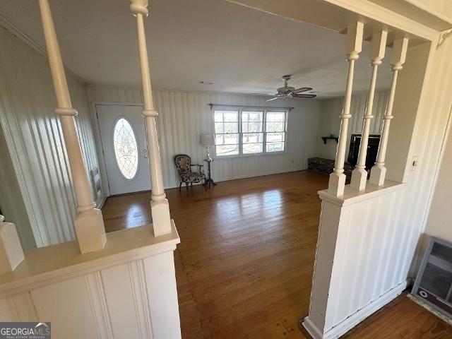 entrance foyer with ceiling fan, dark hardwood / wood-style floors, and decorative columns