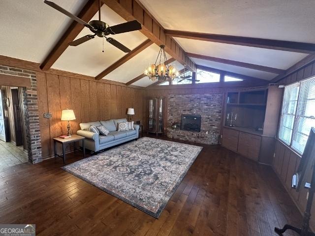 unfurnished living room featuring dark wood-type flooring, a fireplace, and wood walls