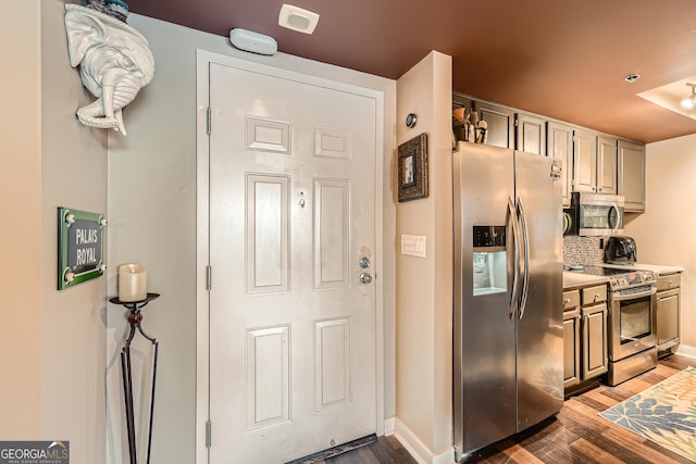 kitchen featuring appliances with stainless steel finishes, dark hardwood / wood-style flooring, and backsplash