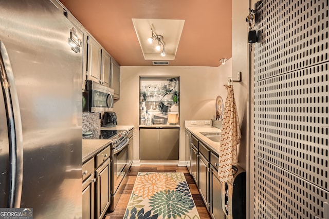 kitchen with tasteful backsplash, appliances with stainless steel finishes, and dark hardwood / wood-style floors