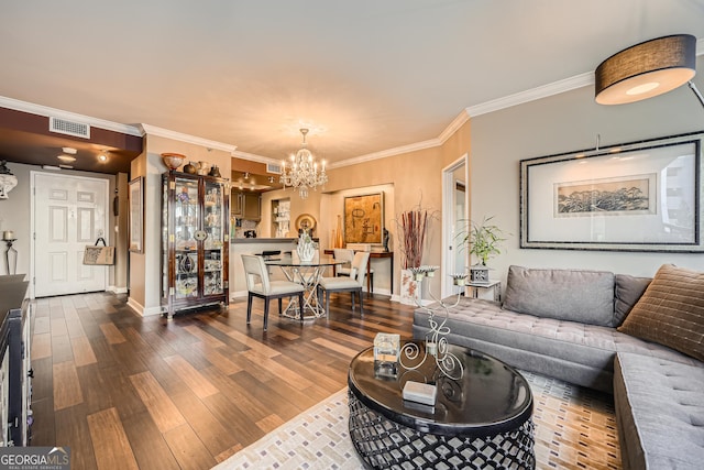 living room with dark wood-type flooring, ornamental molding, and an inviting chandelier