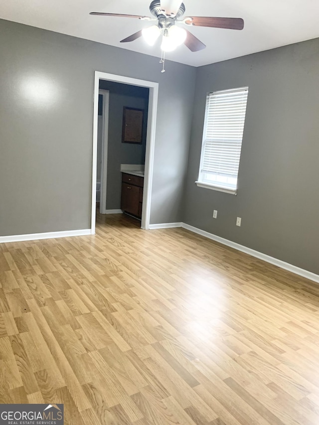 spare room with ceiling fan, baseboards, and light wood-style floors