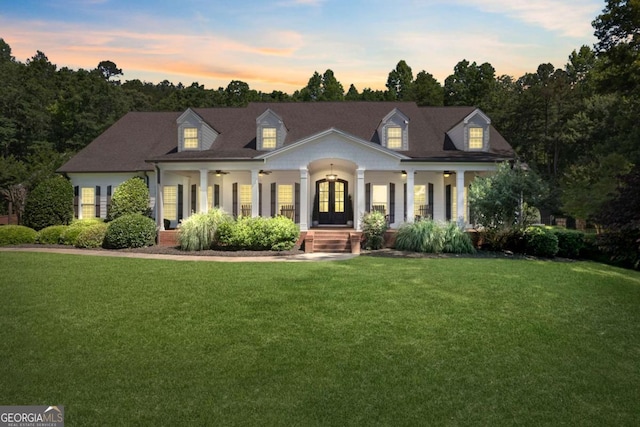 new england style home with a yard and a porch