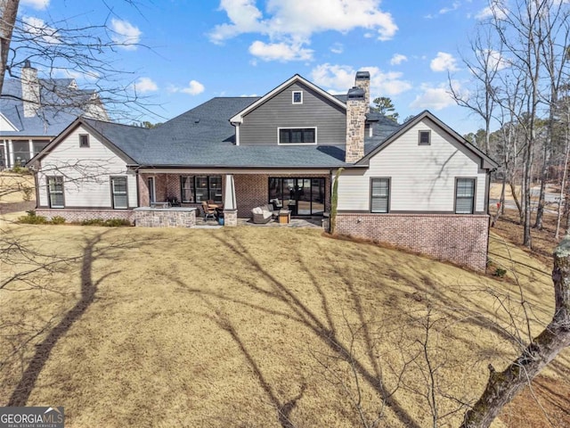 rear view of house with a patio area and a lawn