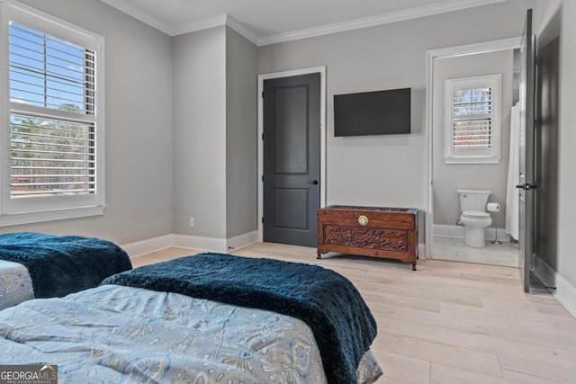 bedroom featuring multiple windows, crown molding, light hardwood / wood-style flooring, and ensuite bath