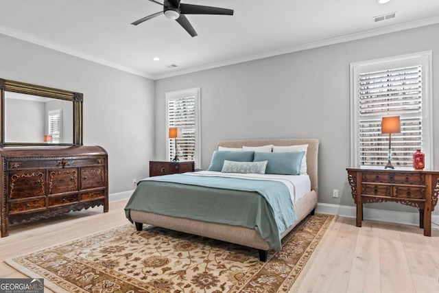 bedroom with hardwood / wood-style flooring, ornamental molding, and ceiling fan