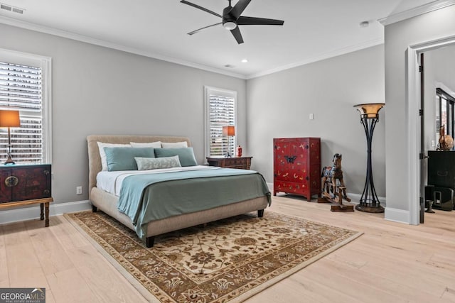 bedroom featuring hardwood / wood-style floors, crown molding, and ceiling fan