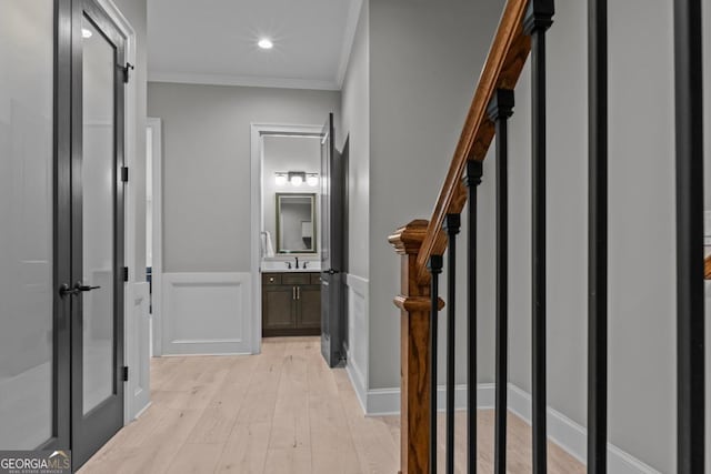 hall with crown molding and light hardwood / wood-style flooring