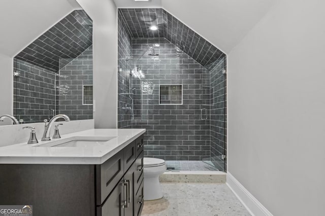 bathroom featuring vanity, vaulted ceiling, toilet, and a tile shower