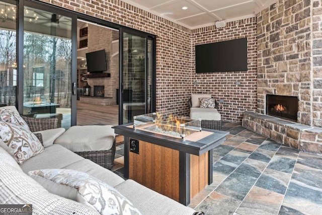 view of patio / terrace featuring ceiling fan, an outdoor fire pit, and an outdoor stone fireplace