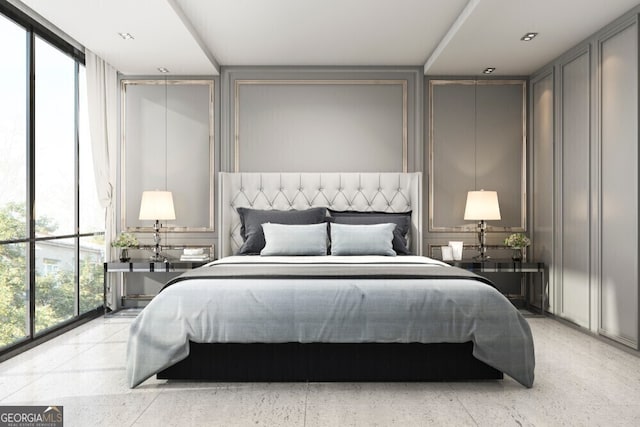 bedroom featuring light speckled floor, a decorative wall, and a wall of windows