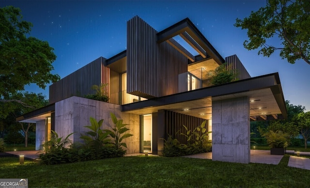 contemporary home with a balcony and a front lawn