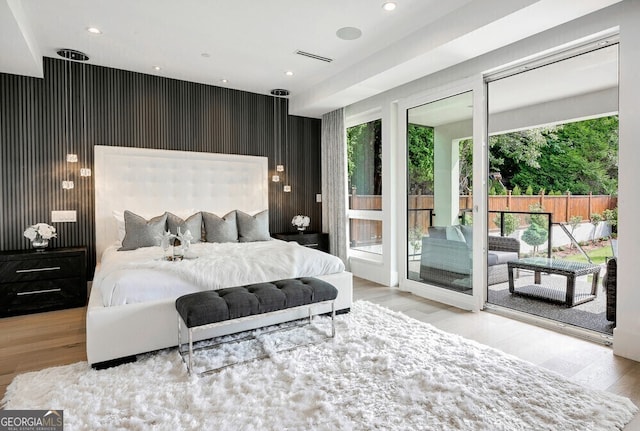 bedroom with wallpapered walls, access to outside, wood finished floors, and recessed lighting