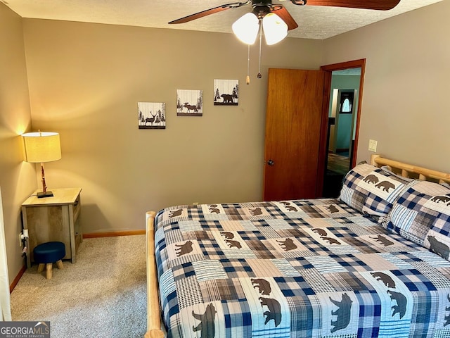 carpeted bedroom featuring ceiling fan and a textured ceiling