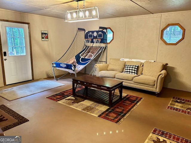 game room with concrete flooring and a chandelier