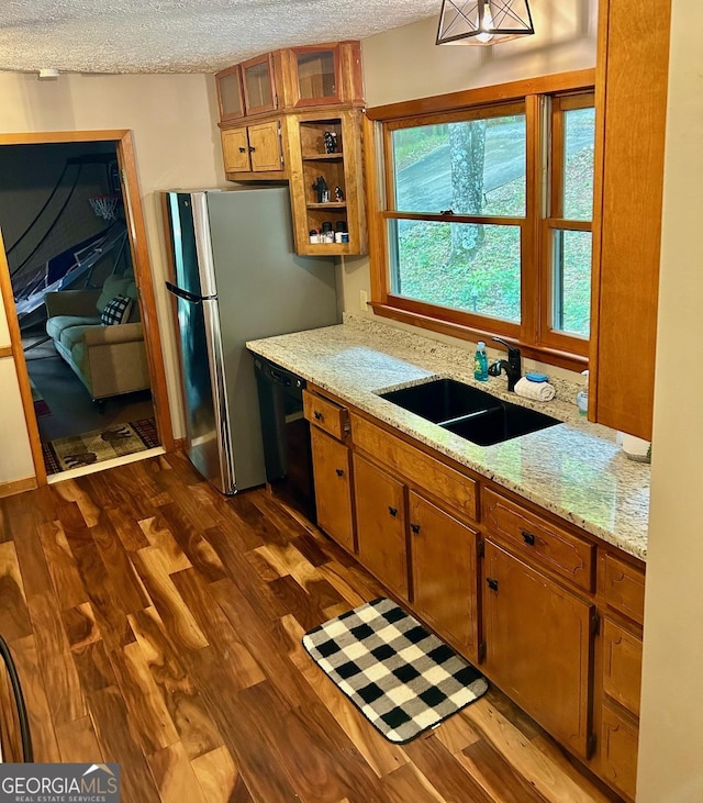 kitchen featuring sink, dishwasher, light stone counters, a textured ceiling, and dark hardwood / wood-style flooring