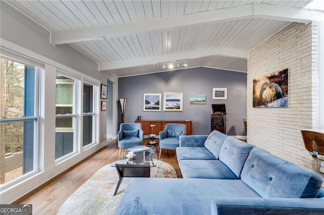 living room featuring wooden ceiling, brick wall, light hardwood / wood-style flooring, and vaulted ceiling with beams