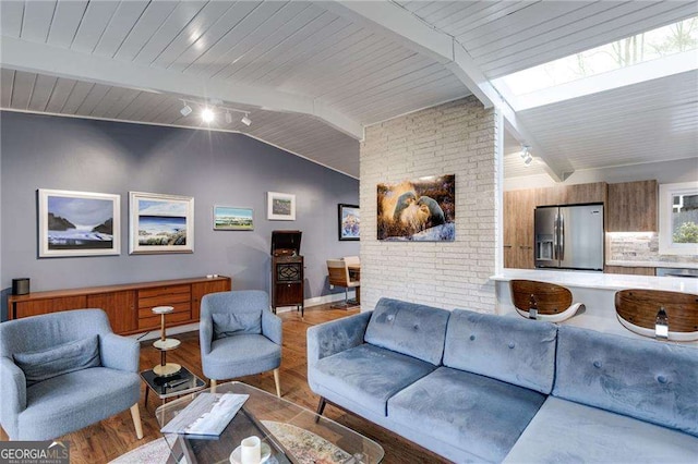 living room with track lighting, lofted ceiling with skylight, light hardwood / wood-style floors, and wooden ceiling