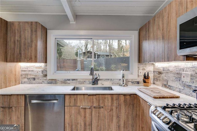 kitchen featuring tasteful backsplash, sink, lofted ceiling with beams, and stainless steel appliances