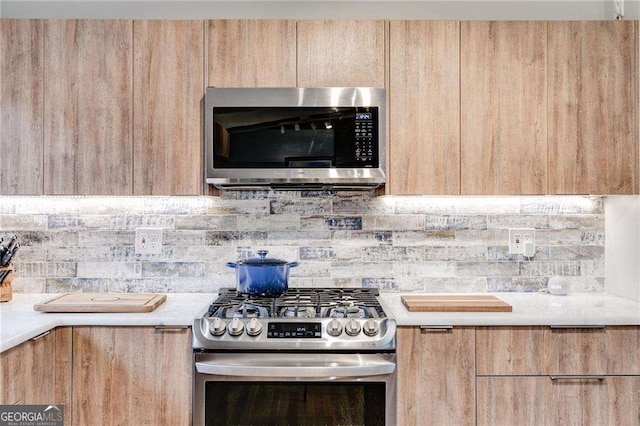 kitchen featuring stainless steel appliances, tasteful backsplash, and light brown cabinetry