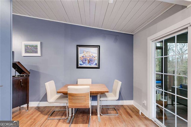 dining space with wood ceiling and light hardwood / wood-style flooring