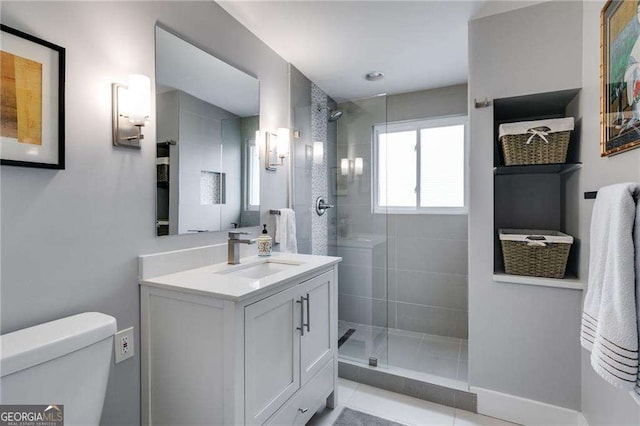 bathroom featuring vanity, a shower with shower door, and toilet