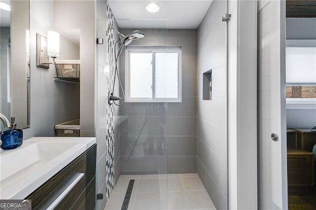 bathroom featuring vanity, plenty of natural light, and tiled shower