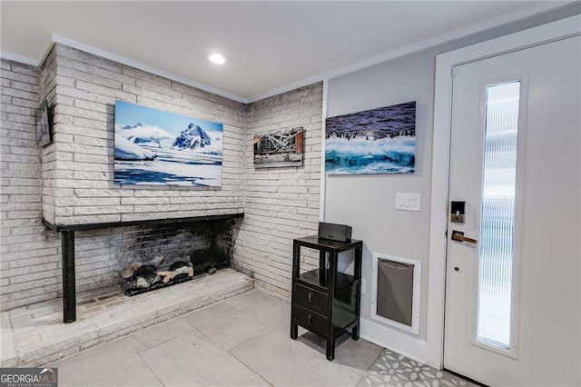 living room featuring crown molding, brick wall, and plenty of natural light