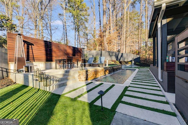 view of yard featuring a pool, area for grilling, and a patio area