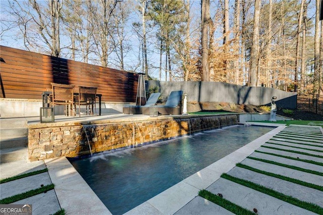 view of swimming pool featuring pool water feature and a patio area