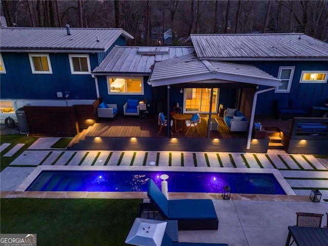 back of property featuring a pool side deck and an outdoor living space