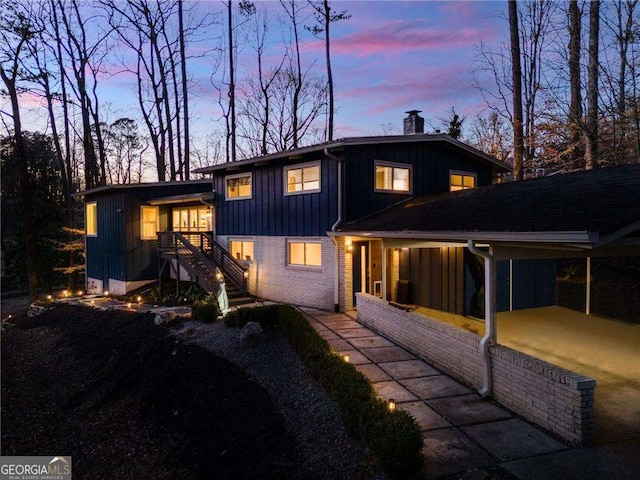 back house at dusk with a carport