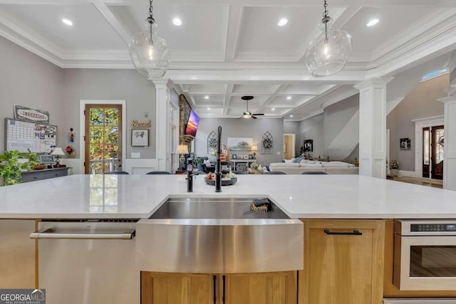 kitchen featuring coffered ceiling, hanging light fixtures, stainless steel dishwasher, and ornate columns