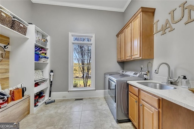 washroom with sink, crown molding, cabinets, separate washer and dryer, and light tile patterned floors